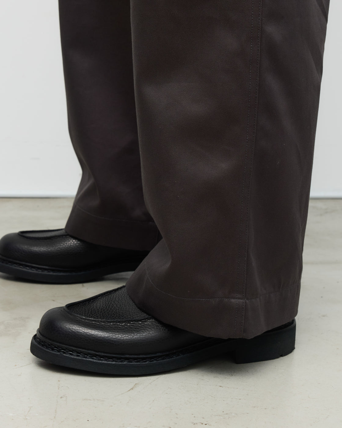 CIOTA製チャコールチノパンツの斜め角度ビュー、45カーキ素材の美しいドレープ性と立体的なパターンカット、日本製トラウザーズの上質さが伝わるアングルショット