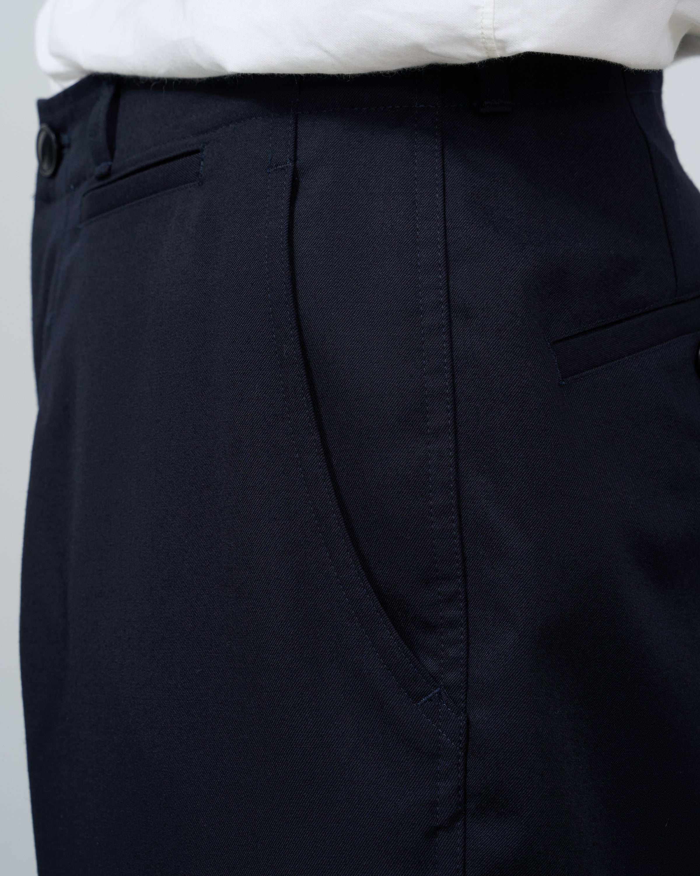 Dhalウールギャバジンチノパンツネイビーの平置き全体写真、classic chino designとpremium wool fabricが織りなすtimeless eleganceの商品撮影