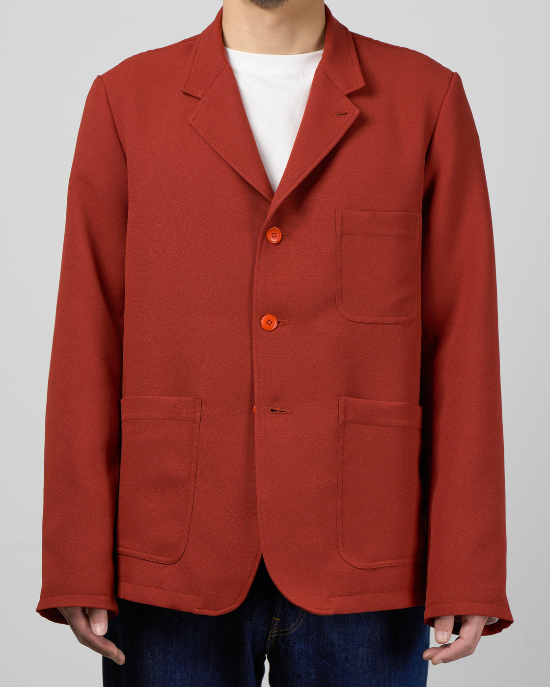 Dhal テーラードジャケットBrickのフロントスタイル詳細、3つボタンの配置とラペルデザイン、ジャージー素材の柔らかな質感とほのかな光沢感、シワになりにくく洗濯可能な実用性、レンガ色の絶妙なトーン、日本製、keylime Tokyo
