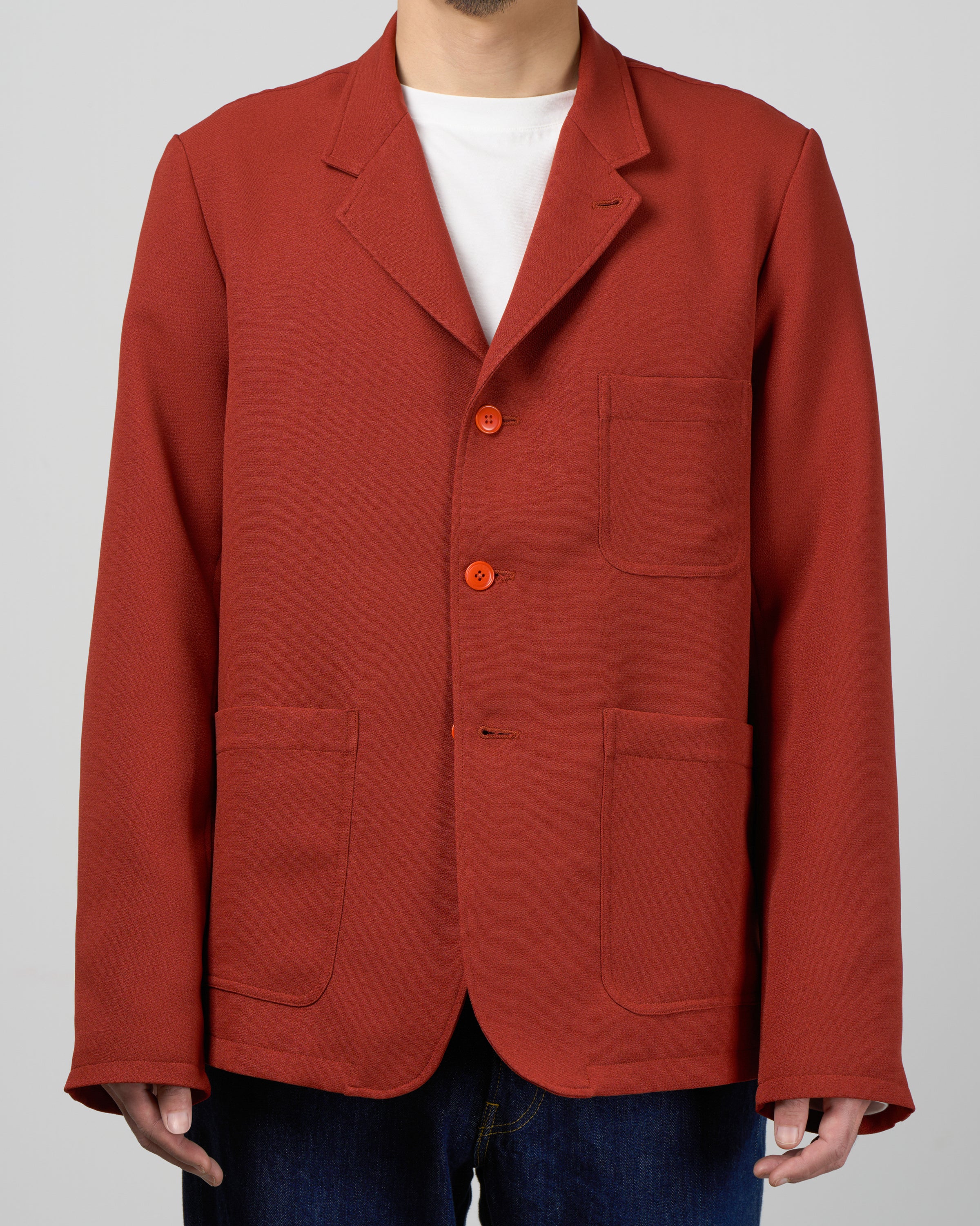 Dhal テーラードジャケットBrickのフロントスタイル詳細、3つボタンの配置とラペルデザイン、ジャージー素材の柔らかな質感とほのかな光沢感、シワになりにくく洗濯可能な実用性、レンガ色の絶妙なトーン、日本製、keylime Tokyo
