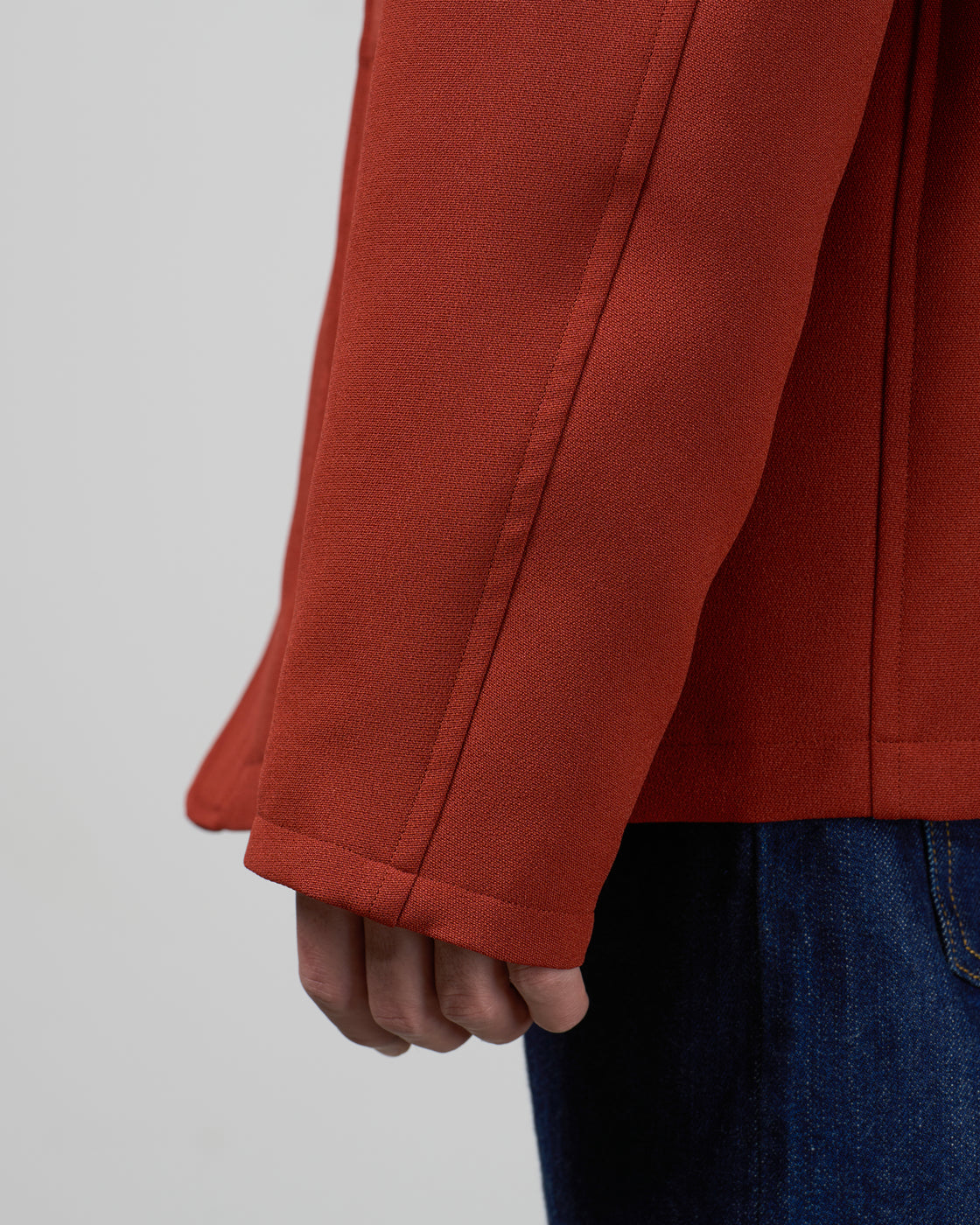  Dhal ジャージーテーラードジャケットの平置き全体像、Brickカラーの3つボタンクラシックデザイン、ポリエステルウーリー糸の二重織り生地、軽量でストレッチ性のある素材感、日本製メンズジャケット、keylime Tokyo、赤でも茶でもない絶妙な個性的カラー