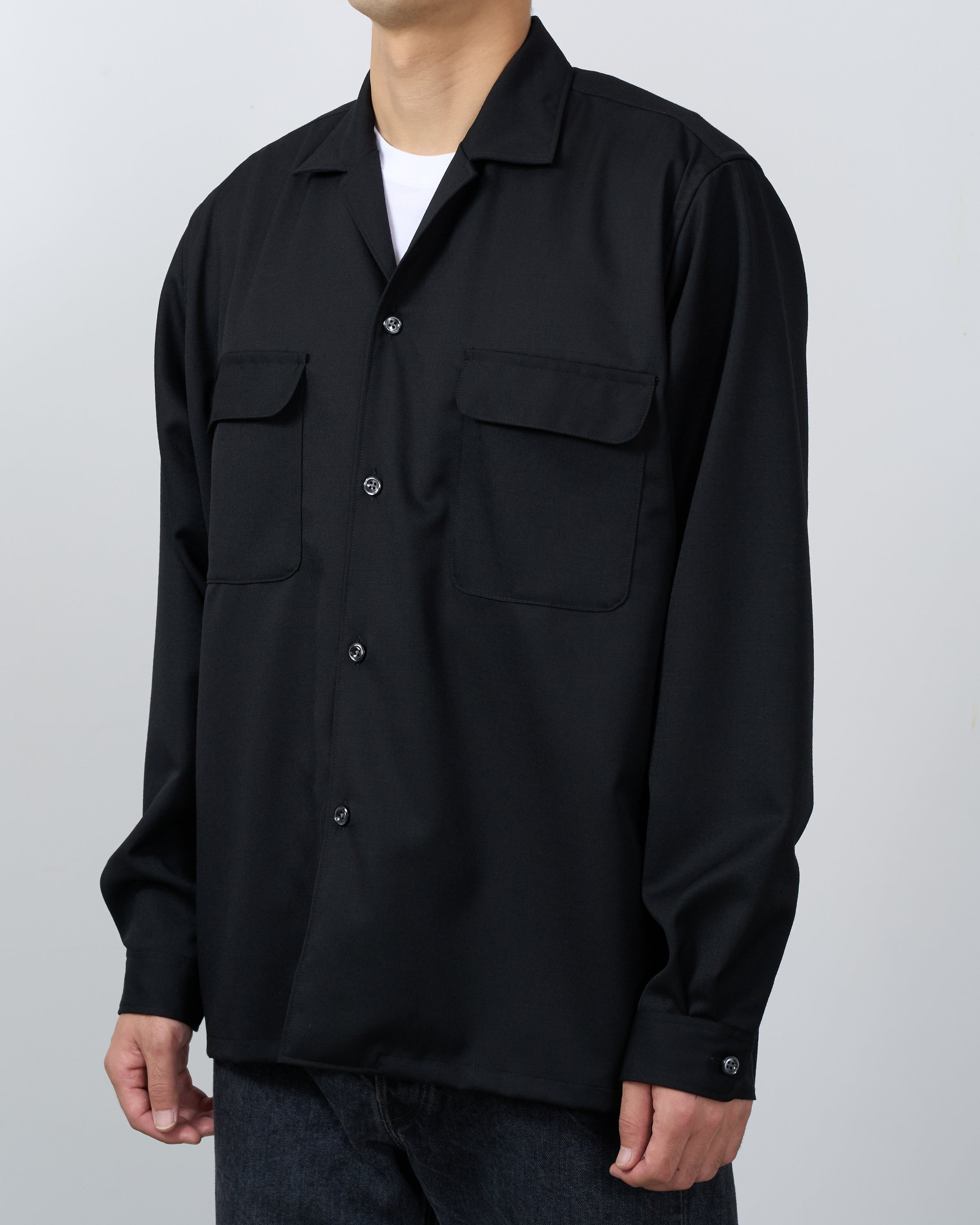 モデルが着用するDhalウールギャバジンシャツの側面スタイリング写真。Black wool gabardine shirt Japanese craftsmanship premium menswear