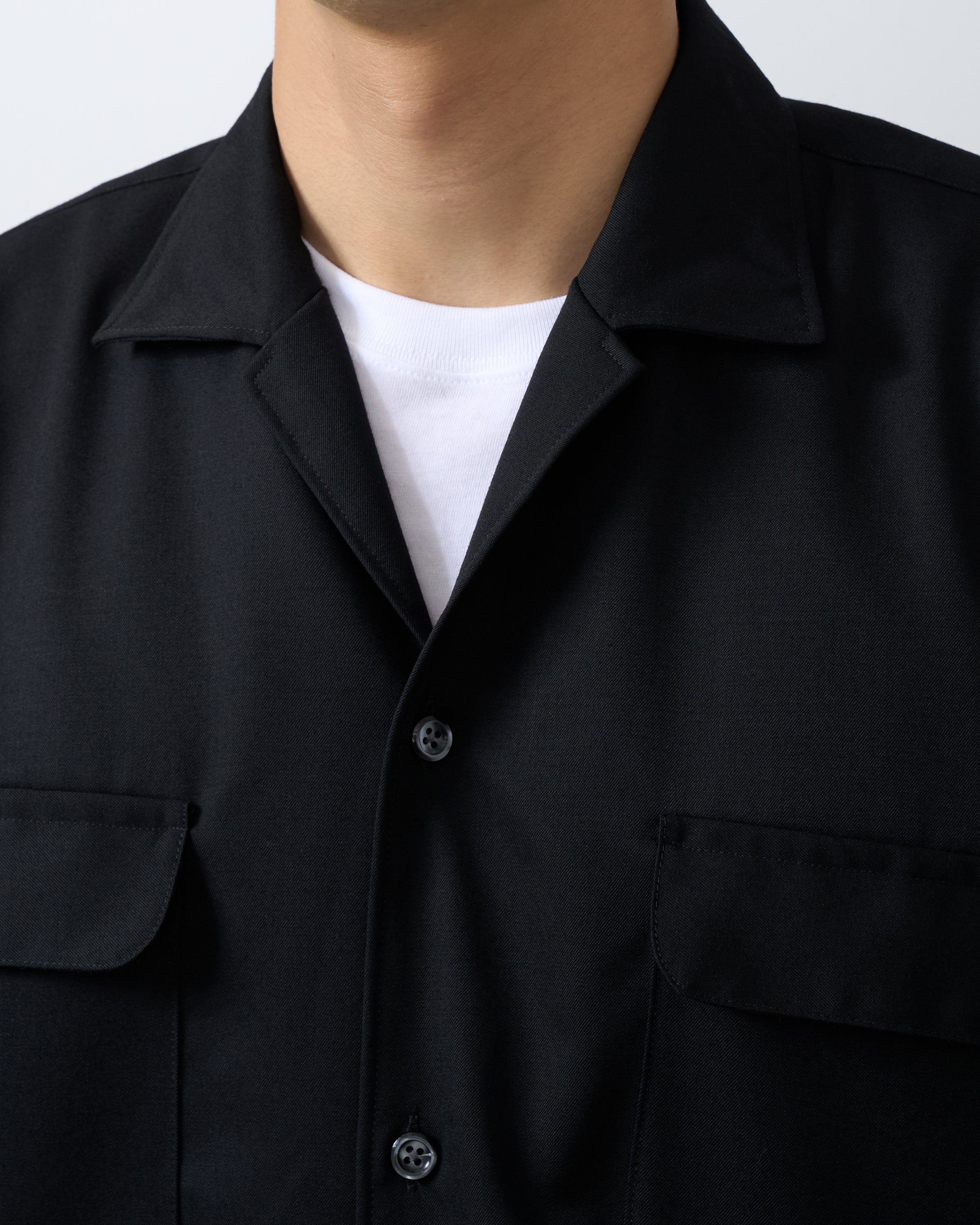 ウールギャバジン素材の質感とブラック色合いが分かるシャツ生地のクローズアップ写真。Wool gabardine fabric texture black premium material