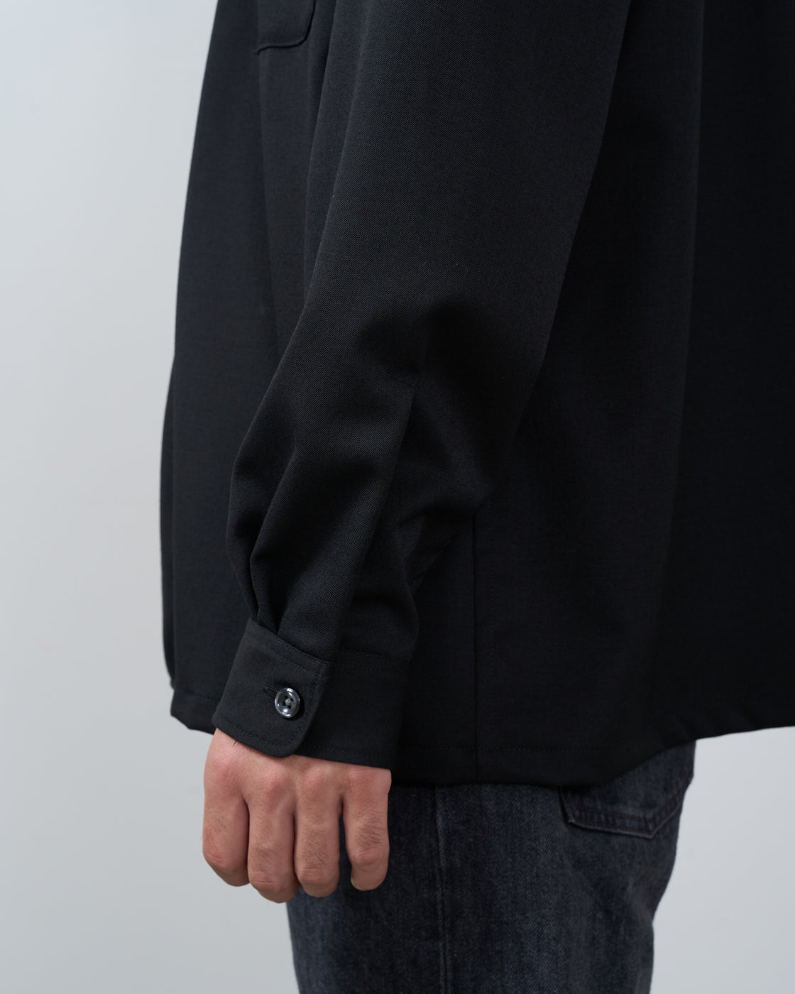 ブラックウールギャバジンオープンカラーシャツの裾部分とサイドシームの縫製詳細写真。Dhal shirt hem construction Japanese craftsmanship
