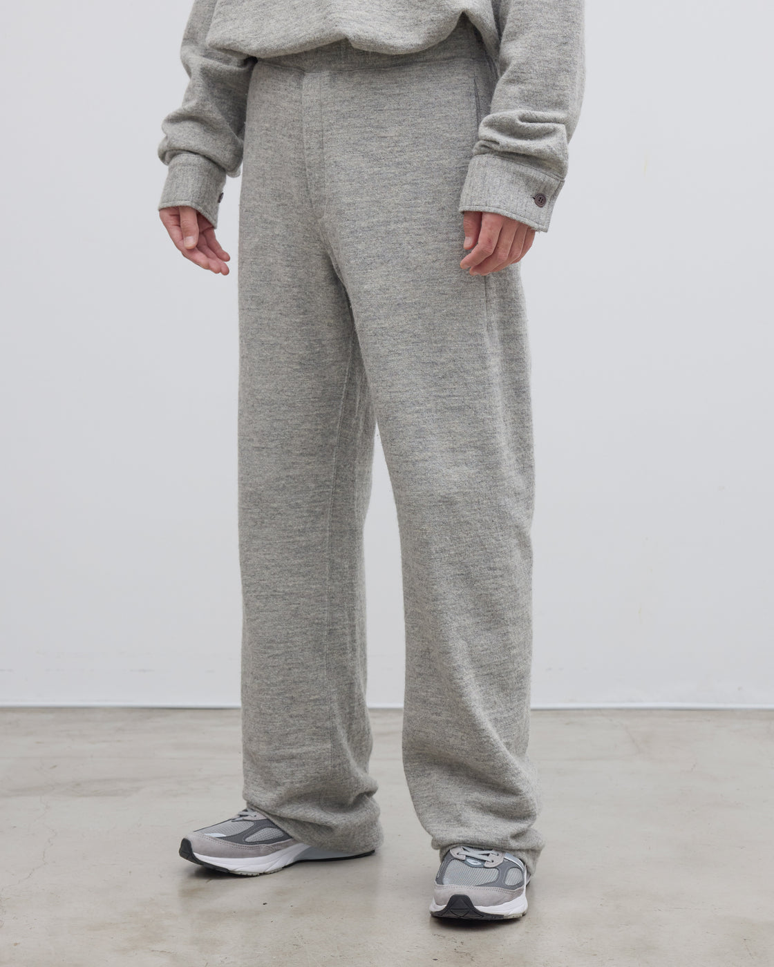 グレーのDhalシェットランドコットンニットパンツの側面から見たシルエット、深めの股上とストレートラインが生み出すリラックスフィットが特徴、日本製の確かな縫製技術が光るイージーパンツ