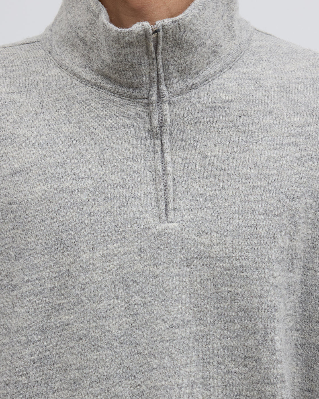 グレーのハーフジップニットプルオーバーの着用シーン、シェットランドウールとコットンのメランジ糸が生み出すふっくらとした風合いと上質な肌触りが魅力の尾州製ニットウェア