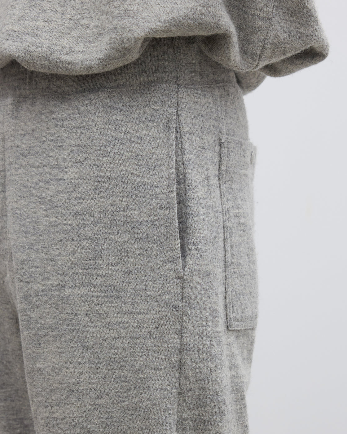 Keylime Tokyoのシェットランドウール混ニットパンツのストレートシルエットが際立つ着用シーン、杢調メランジ感と深めの股上が特徴的なグレーのイージーパンツ、尾州産素材