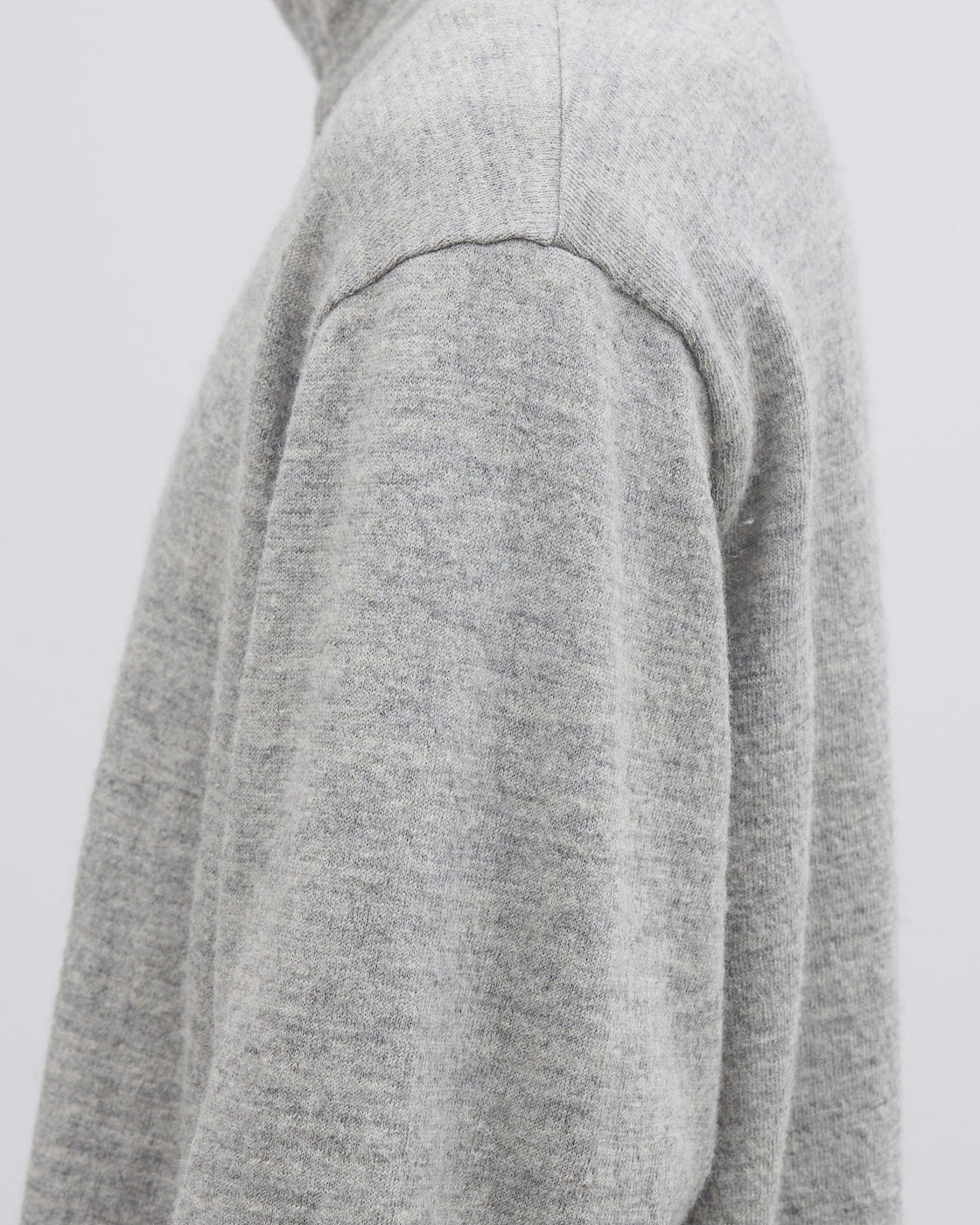 Dhalのシェットランドコットンヘザーニットジッププルオーバーを着用したモデルの全身写真、日本製ならではの丁寧な編み立てと縮絨加工による柔らかな質感が際立つニットウェア