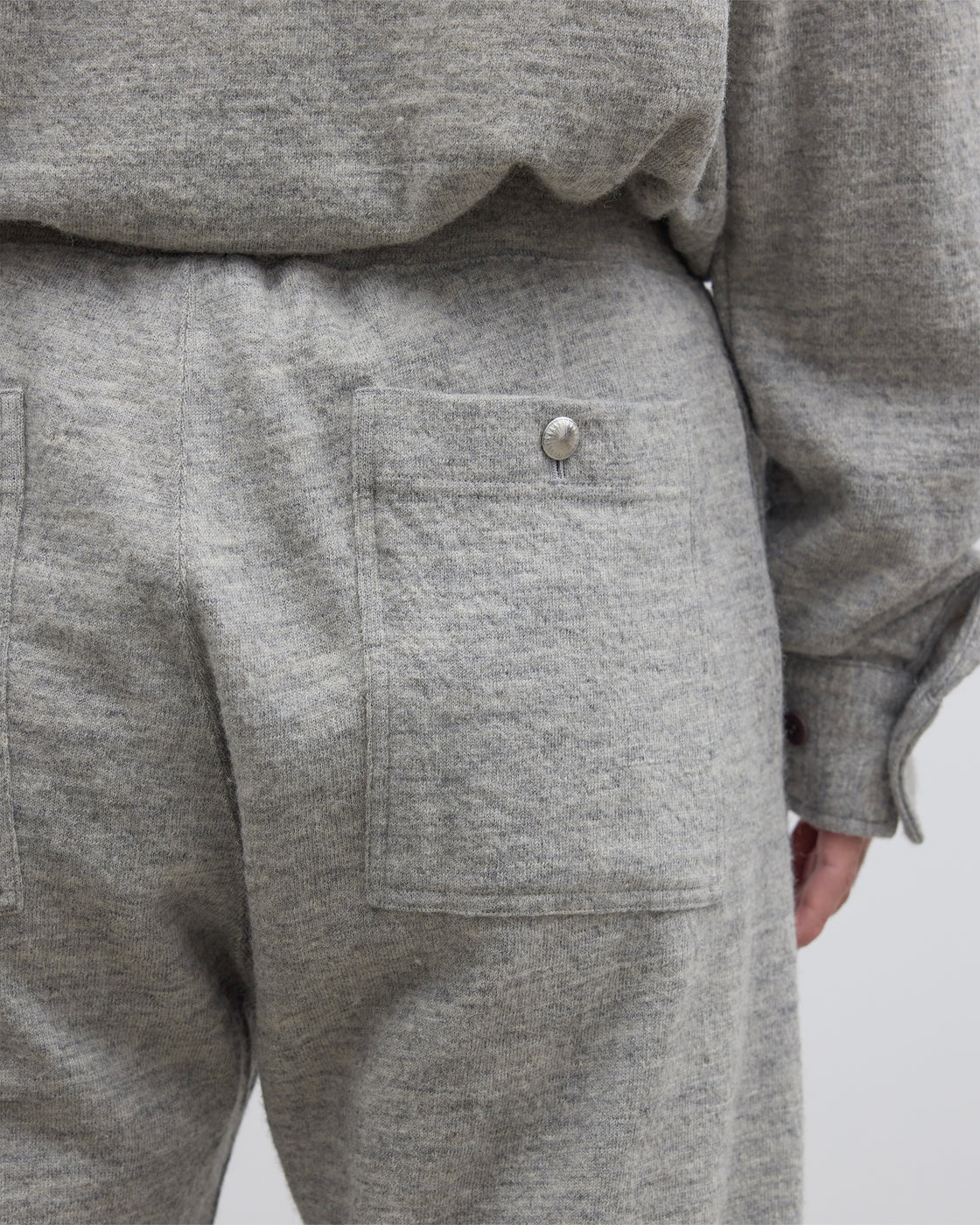 グレーのDhalシェットランドコットンニットパンツの平置き全体像、ストレートシルエットと杢調メランジ感が一目でわかる日本製イージーパンツ、尾州産ウール混紡素材の上質な風合い
