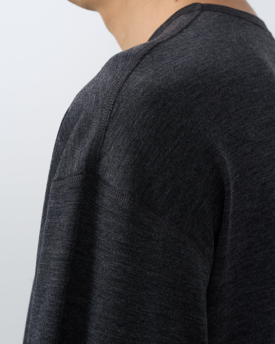 holkブランドメリノウールlong sleeve teeチャコール色、モデル着用横向きポーズ、上品なhigh-gauge knitのような仕上がりを表現したwool